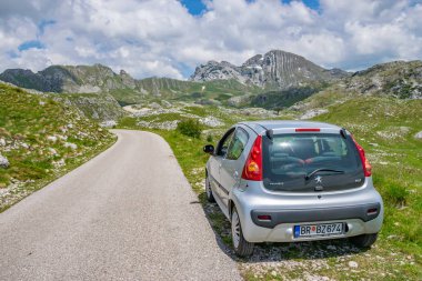 Karadağ, Durmitor - 07 Haziran 2017: turist Park edilmiş araba üzerinde yüksek dağlar yol kenarı 