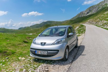 Karadağ, Durmitor - 07 Haziran 2017: turist Park edilmiş araba üzerinde yüksek dağlar yol kenarı 