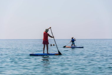 Karadağ, Budva - 05 Haziran 2017: turist (Sup) üstünde tahta kürek sakin deniz yüzeyinde nişanlı