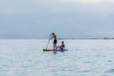 Karadağ, Budva - 05 Haziran 2017: turist (Sup) üstünde tahta kürek sakin deniz yüzeyinde nişanlı