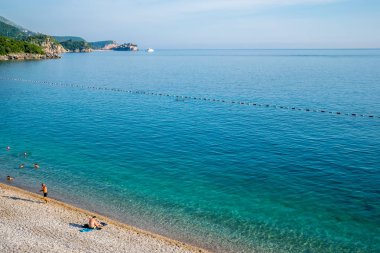 Karadağ, Przno - 05 Haziran 2017: Adriyatik Denizi'nde günbatımı sırasında yüzme turist.