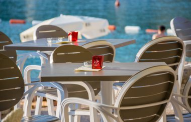 Karadağ, Becici - 05 Haziran 2017: Restoran personeli tablolar deniz kenarında yemek gün batımı sırasında hazırlanan