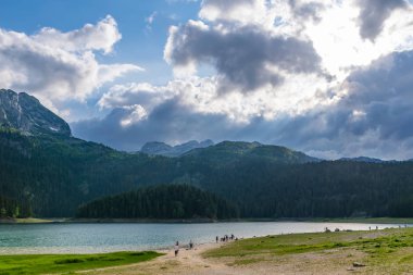 Kuzeyinde Karadağ Milli Parkı Durmitor içinde muhteşem siyah Lake yakınlarında oturan insanlar