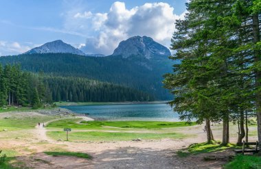 Kuzeyinde Karadağ Milli Parkı Durmitor içinde muhteşem siyah Lake yakınlarında oturan insanlar