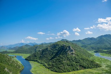 Pitoresk yemyeşil dağlar arasında akan nehir akar.