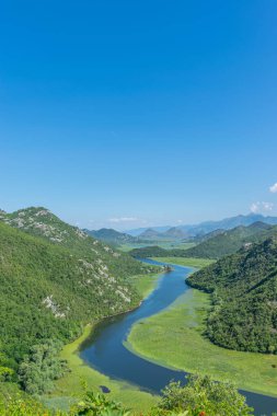 Pitoresk yemyeşil dağlar arasında akan nehir akar.