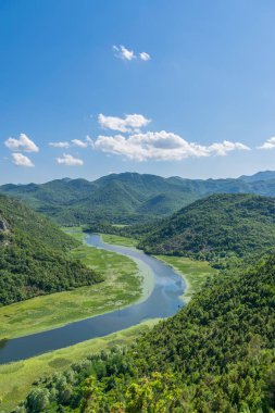 Pitoresk yemyeşil dağlar arasında akan nehir akar.