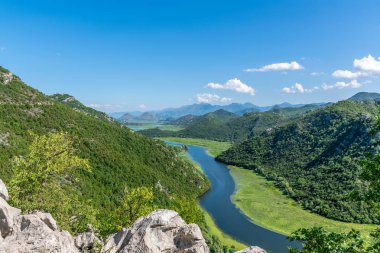 Pitoresk yemyeşil dağlar arasında akan nehir akar.