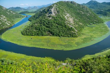 Pitoresk yemyeşil dağlar arasında akan nehir akar.