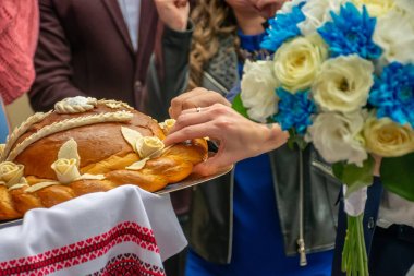 Geleneklere göre, ebeveynler yeni evlilerle ekmek ve tuzla tanışır..