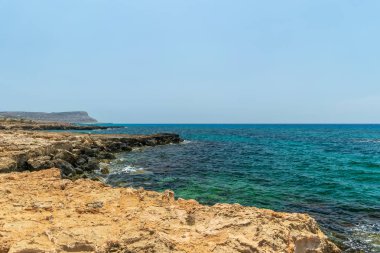 Deniz dalgaları kayalık kıyıya vuruyor.