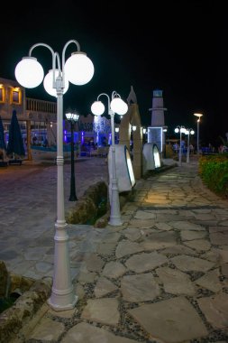 Kıbrıs, Ayia Napa - 10/10/2018: Turistler lezzetli bir taverna aramak için gece gezintiboyunca yürüyüş.