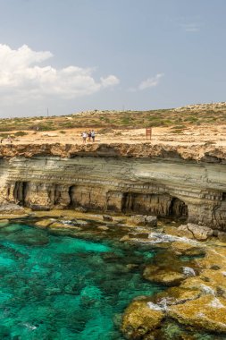 Kıbrıs, Aya Napa - 11 Mayıs 2008: Turistler pitoresk deniz mağaraları yakınında sahil boyunca yürüyüş.