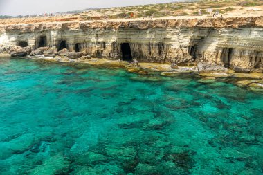 Kıbrıs, Aya Napa - 11 Mayıs 2008: Turistler pitoresk deniz mağaraları yakınında sahil boyunca yürüyüş.