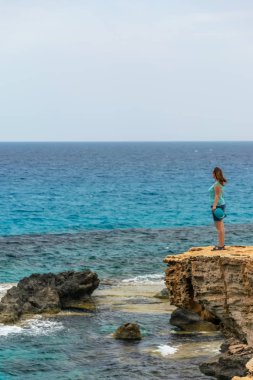 Genç güzel kız hafif deniz esintisinin tadını çıkarıyor..
