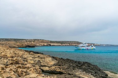 Kıbrıs, Cape Cavo Greco - 11.Mayıs 2018: Turistler yüzmek için mavi lagüne giden bir gemiyle denize açıldı.