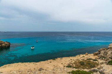 Kıbrıs, Cape Cavo Greco - 11.Mayıs 2018: Turistler yüzmek için mavi lagüne motorlu tekneyle gittiler.