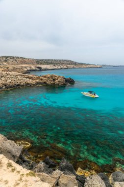 Kıbrıs, Cape Cavo Greco - 11.Mayıs 2018: Turistler yüzmek için mavi lagüne motorlu tekneyle gittiler.
