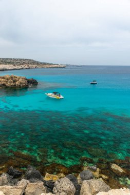 Kıbrıs, Cape Cavo Greco - 11.Mayıs 2018: Turistler yüzmek için mavi lagüne motorlu tekneyle gittiler.