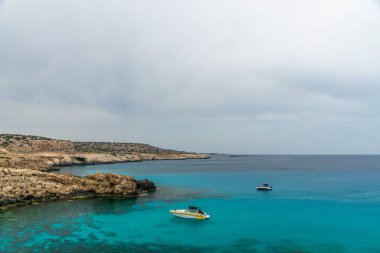 Kıbrıs, Cape Cavo Greco - 11.Mayıs 2018: Turistler yüzmek için mavi lagüne motorlu tekneyle gittiler.