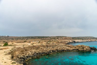 Kıbrıs, Cape Cavo Greco - 11.Mayıs 2018: Turistler yüzmek için mavi lagüne arabayla geldi.