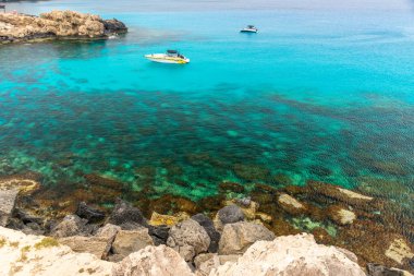 Kıbrıs, Cape Cavo Greco - 11.Mayıs 2018: Turistler yüzmek için mavi lagüne motorlu tekneyle gittiler.