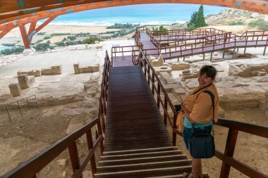 Köprüde okyanus manzaralı genç bir kadının arka görüntüsü.