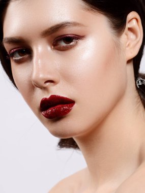 Şık dudaklı, kırmızı rujlu, uzun kirpikli bir model.