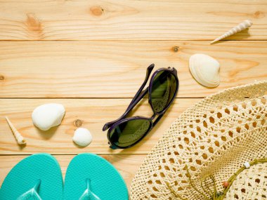 Parmak arası terlik, güneş gözlüğü ve plaj şapka ahşap arka plan üzerinde. Bayan beachwear aksesuarlar kopya alanı ile. Yaz tatil kavramı.