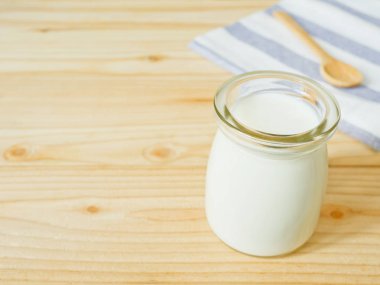 Sade yoğurt ahşap tablo kopya alanı bir kavanoz. Sağlıklı gıda kavramı.