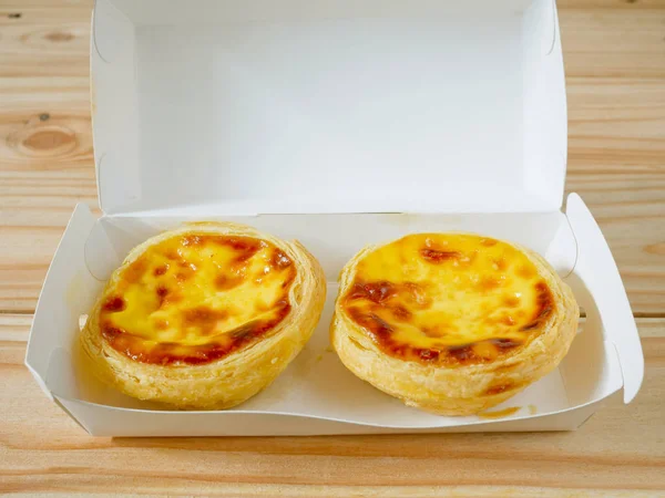 Fresh baked egg tarts or custard tarts (pastel de nata) in a takeaway box