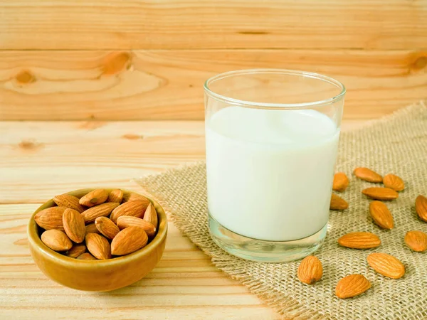Ahşap masa üzerinde kabuklu badem ile badem süt