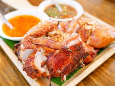 Izgara tavuk ahşap plaka üzerinde tatlı ve baharatlı sos ile servis