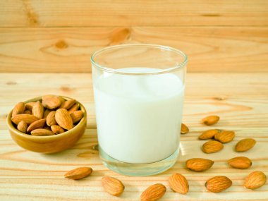 Ahşap masa üzerinde kabuklu badem ile badem süt