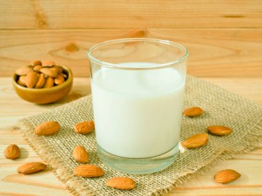 Ahşap masa üzerinde kabuklu badem ile badem süt