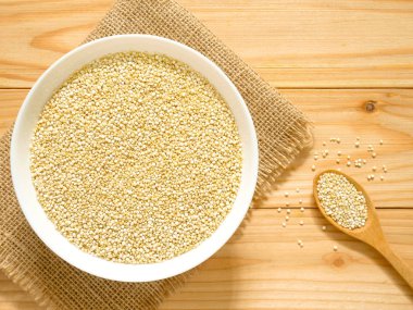 Bir kase çiğ beyaz Quinoa ahşap masa üzerinde. Üstten görünüm.