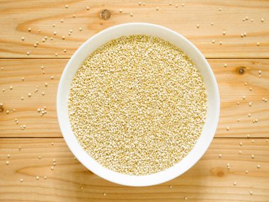 Bir kase çiğ beyaz Quinoa ahşap masa üzerinde. Üstten görünüm.