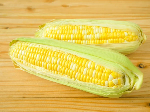 Ears of bicolor sweet corn on rustic wooden background