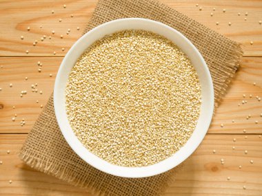 Bir kase çiğ beyaz Quinoa ahşap masa üzerinde. Üstten görünüm.