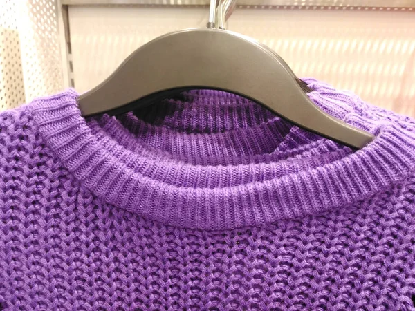 Knitted clothing hanged in boutique shop in shopping mall for winter season