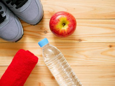 Egzersiz ve fitness ekipmanları ile kopya alanı ile spor salonunda ahşap arka plan üzerinde kırmızı elma. Üstten görünüm. Sağlık kavramı