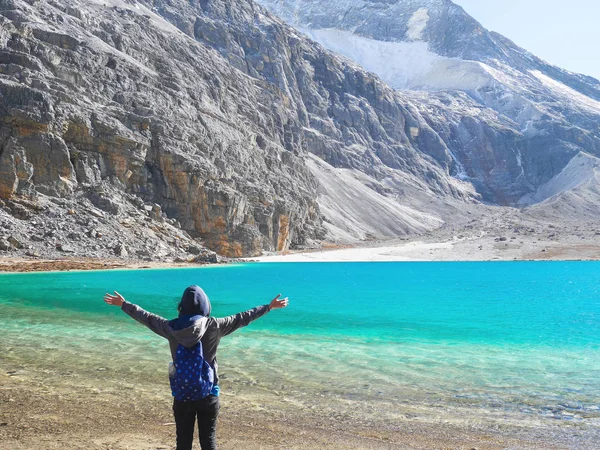 Genç kadın elleri kadar havada bitirdikten sonra yükselterek süt Gölü Yading doğa rezerv trekking.