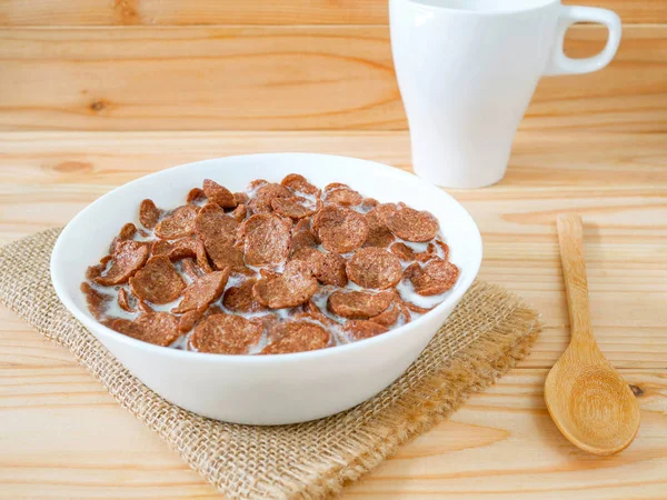木製テーブルの上の白いボウルにコーンフレークをチョコレート 健康的な朝食のコンセプト — ストック写真