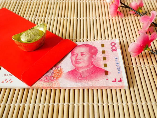 Kırmızı zarf veya ahşap arka plan üzerinde kırmızı paketlerden Çin yuan para yığını. Çin yeni yılı konsept.