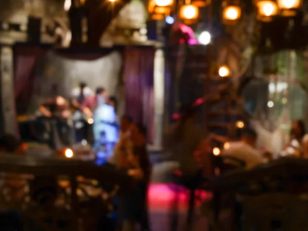 Blurred musicians playing live music with people drinking at the decorative bar