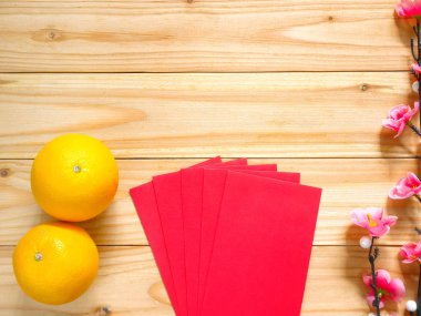 Çin yeni yıl süslemeleri. Kırmızı paketleri, portakal ve erik çiçeği. Üstten görünüm. Kopya alanı.