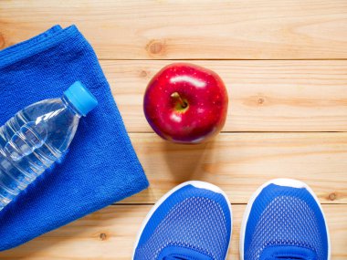 Egzersiz ve fitness ekipmanları ile kopya alanı ile spor salonunda ahşap arka plan üzerinde kırmızı elma. Üstten görünüm. Sağlık kavramı