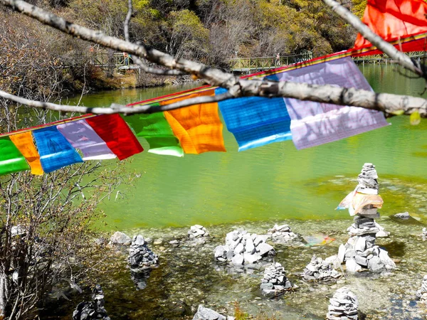 Empilhamento de pedras e bandeiras de oração coloridas — Fotografia de Stock
