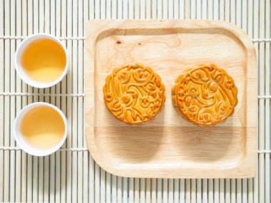 Çay bardak ile ahşap bir tabak üzerinde Mooncakes 