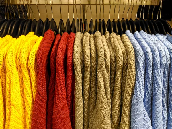 Sweaters knitted clothes hanging in boutique shop — Stock Photo, Image